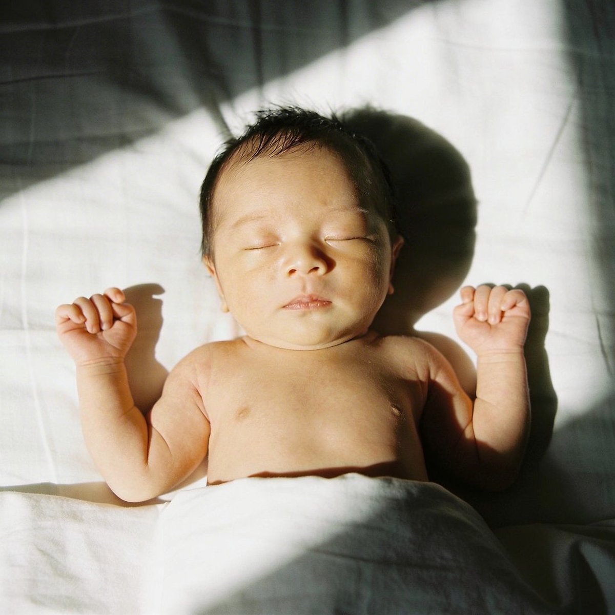 Vauva kuvattuna pehmeässä luonnonvalossa ikkunan lähellä 45 asteen kulmassa